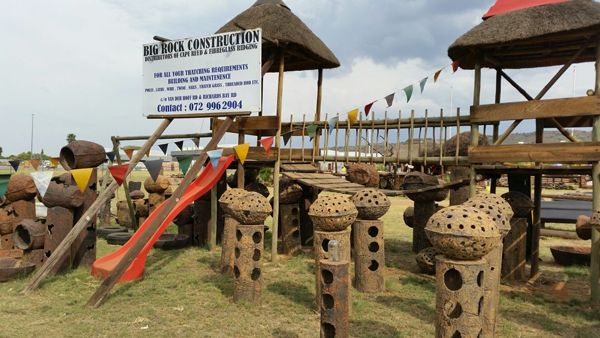 Timber jungle gym with a slide and thatched caps